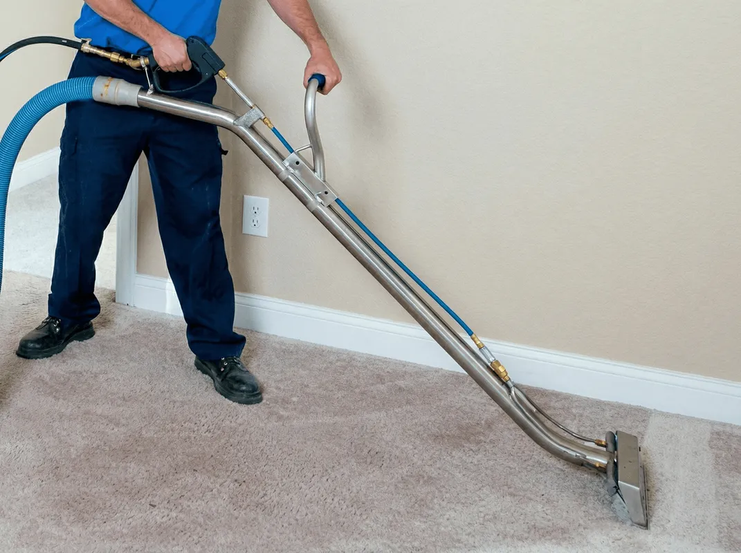 Professional operating a liquid removal machine on a carpeted floor in Buffalo, NY